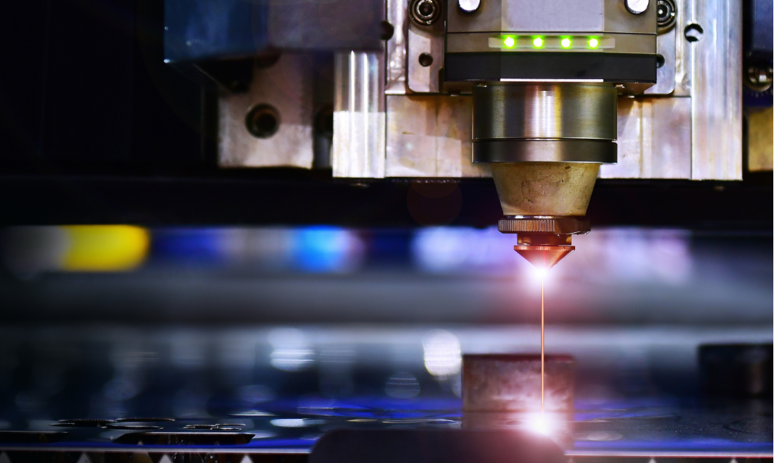 Laser cutting head working on a sheet of material